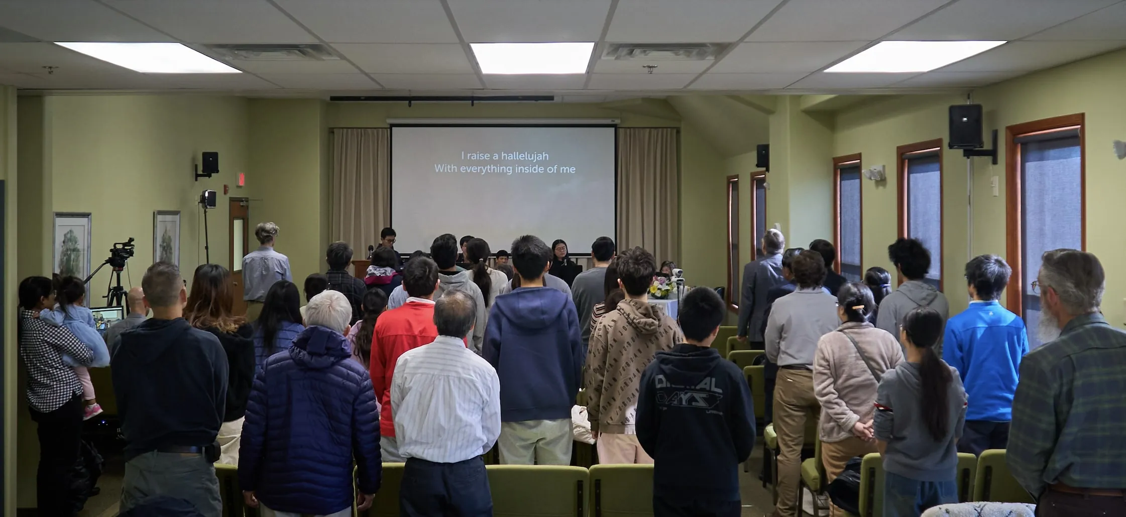 Congregation standing for worship in the WCEC sanctuary